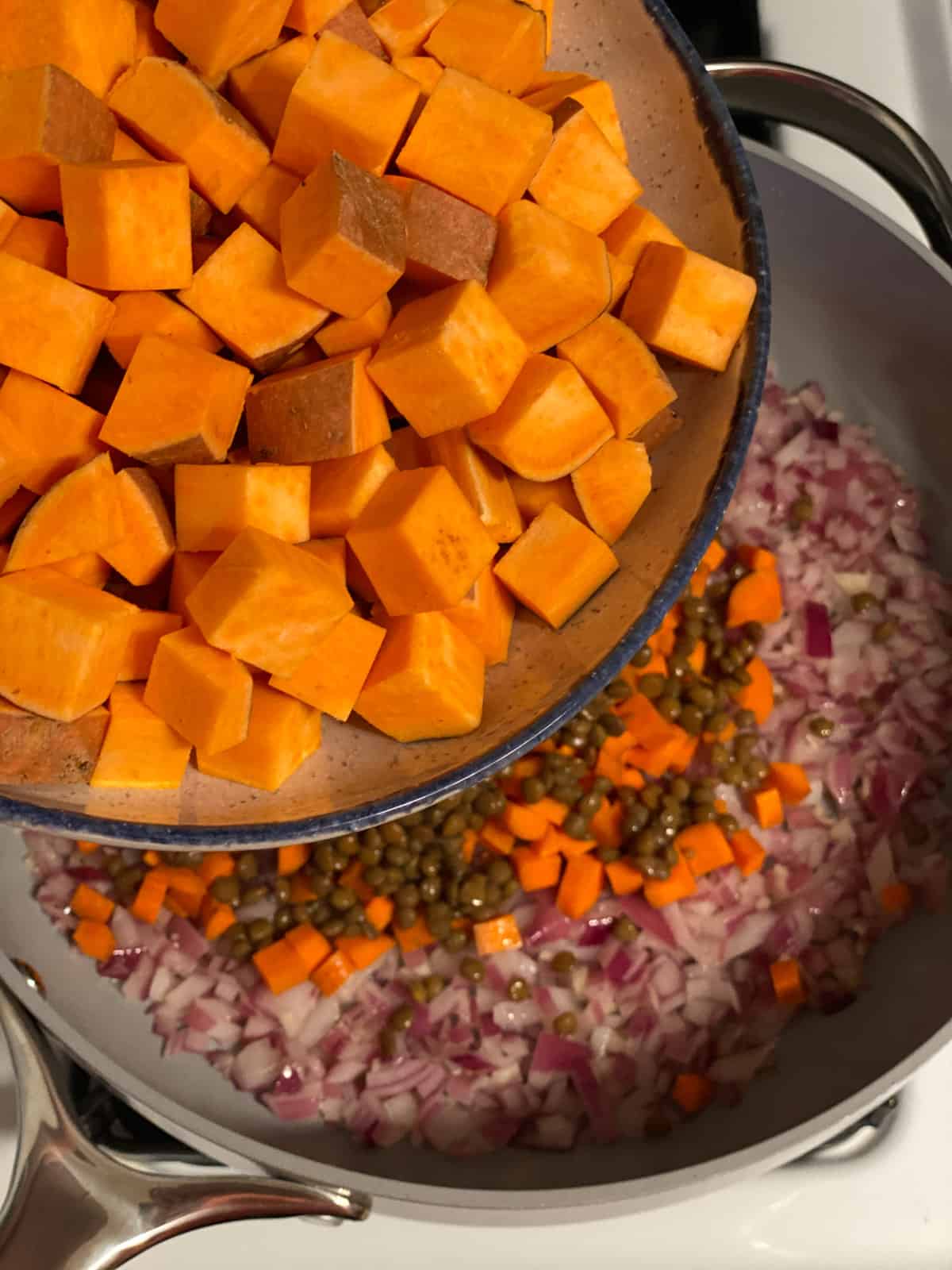 process shot of adding sweet potatoes to pan