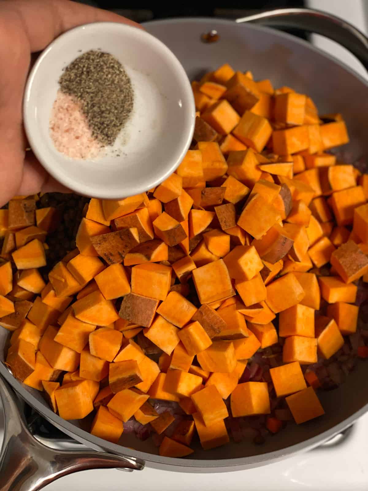 process shot of adding seasonings to pan