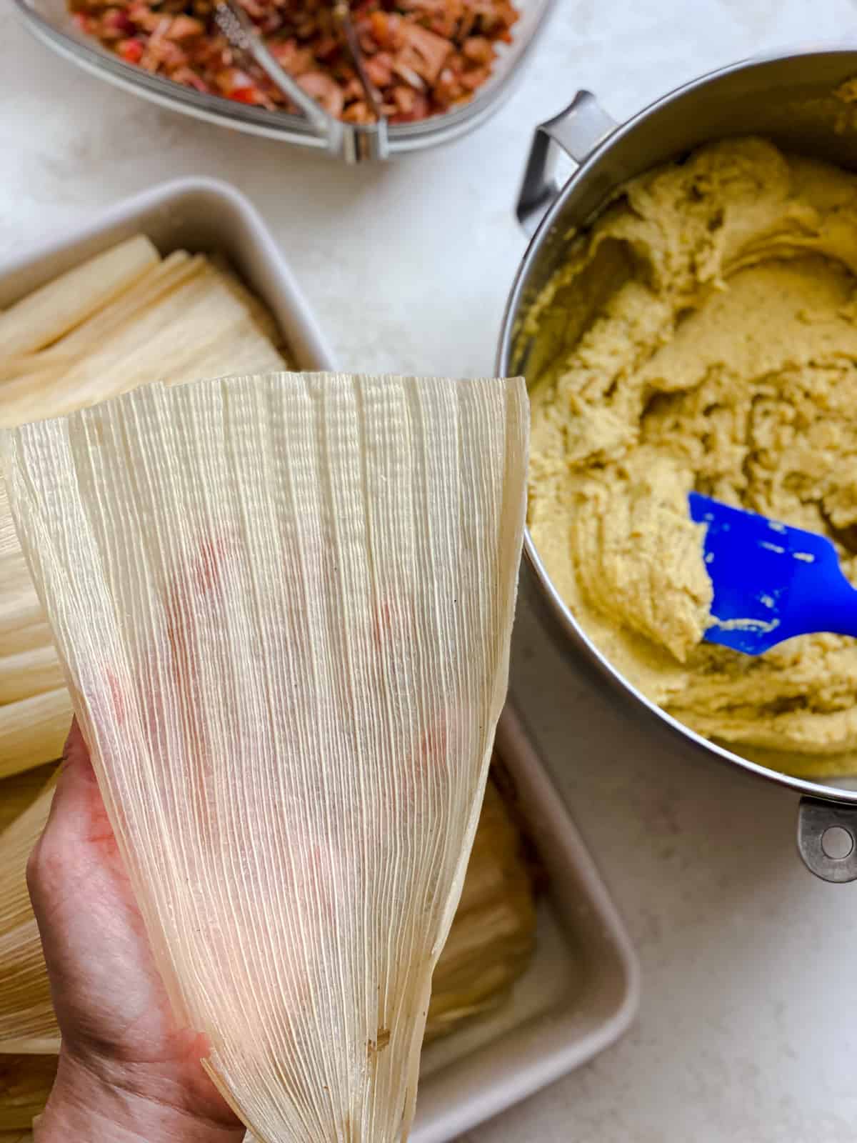 process shot of preparing corn husk for filling for tamales