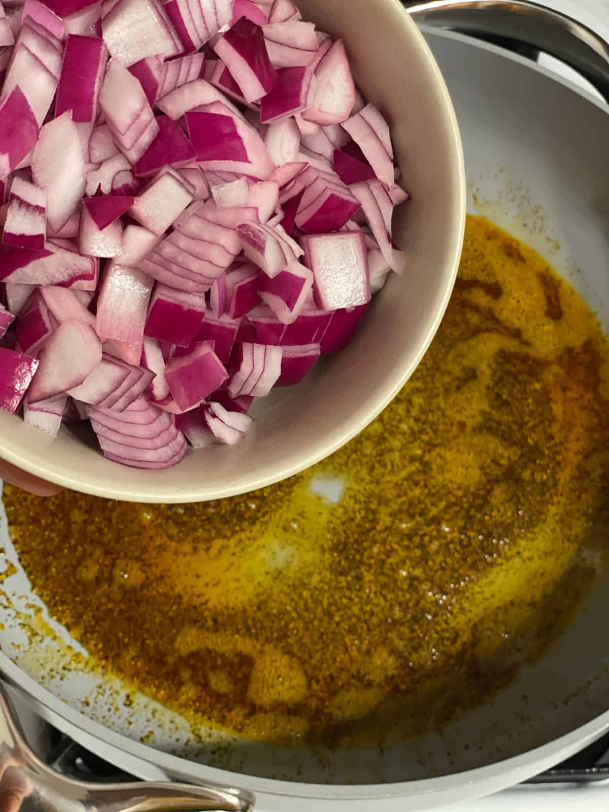 process shot of adding onions to pan