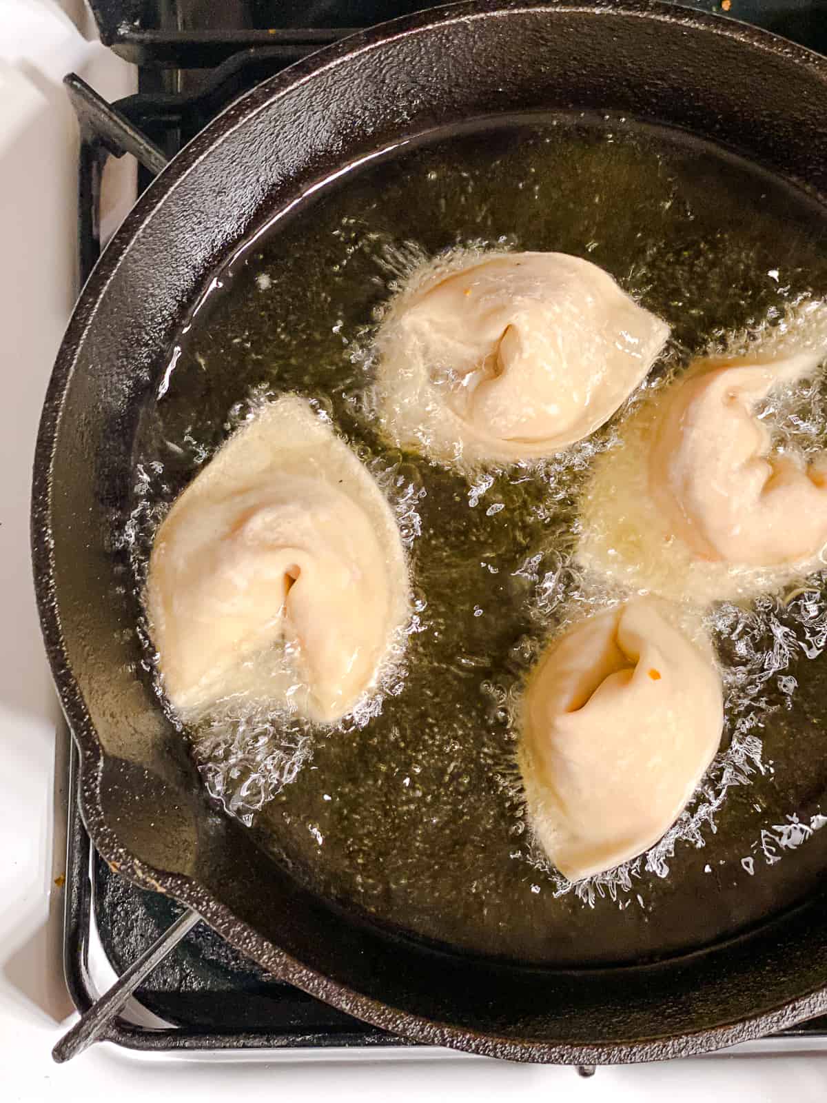 process shot of frying wontons in pan