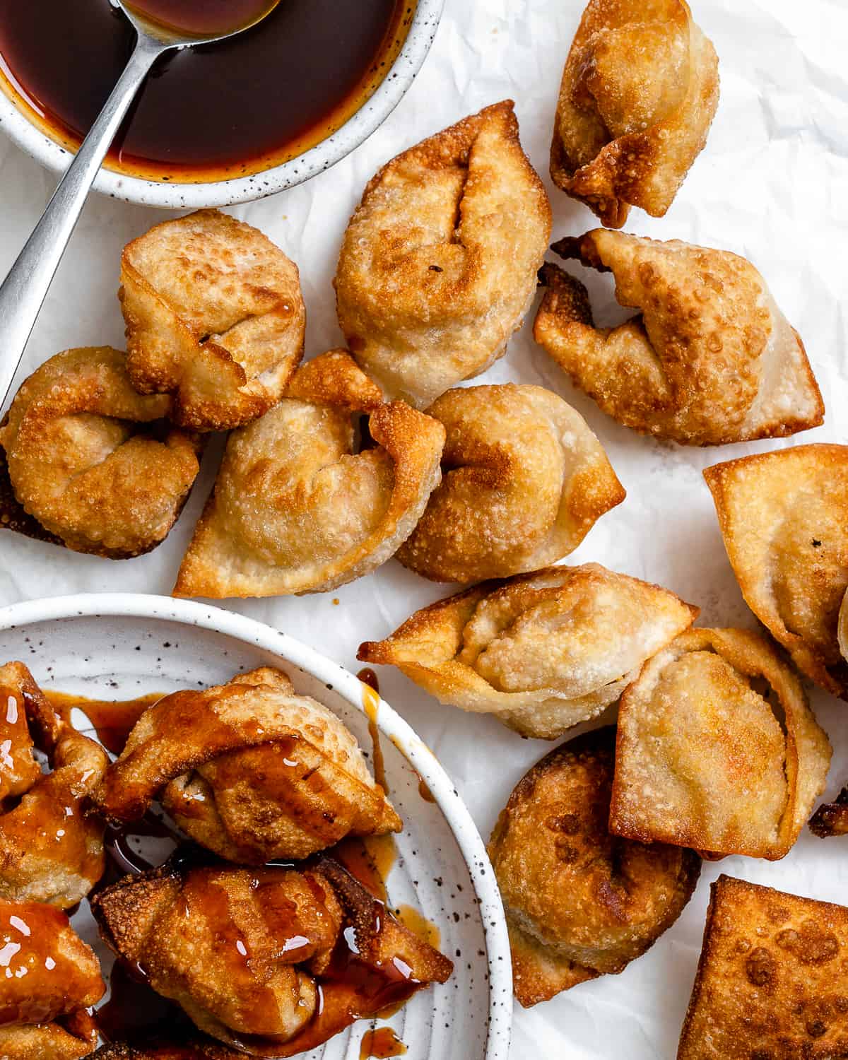 several completed Tofu Vegetable Crispy Wontons spread out on a white surface