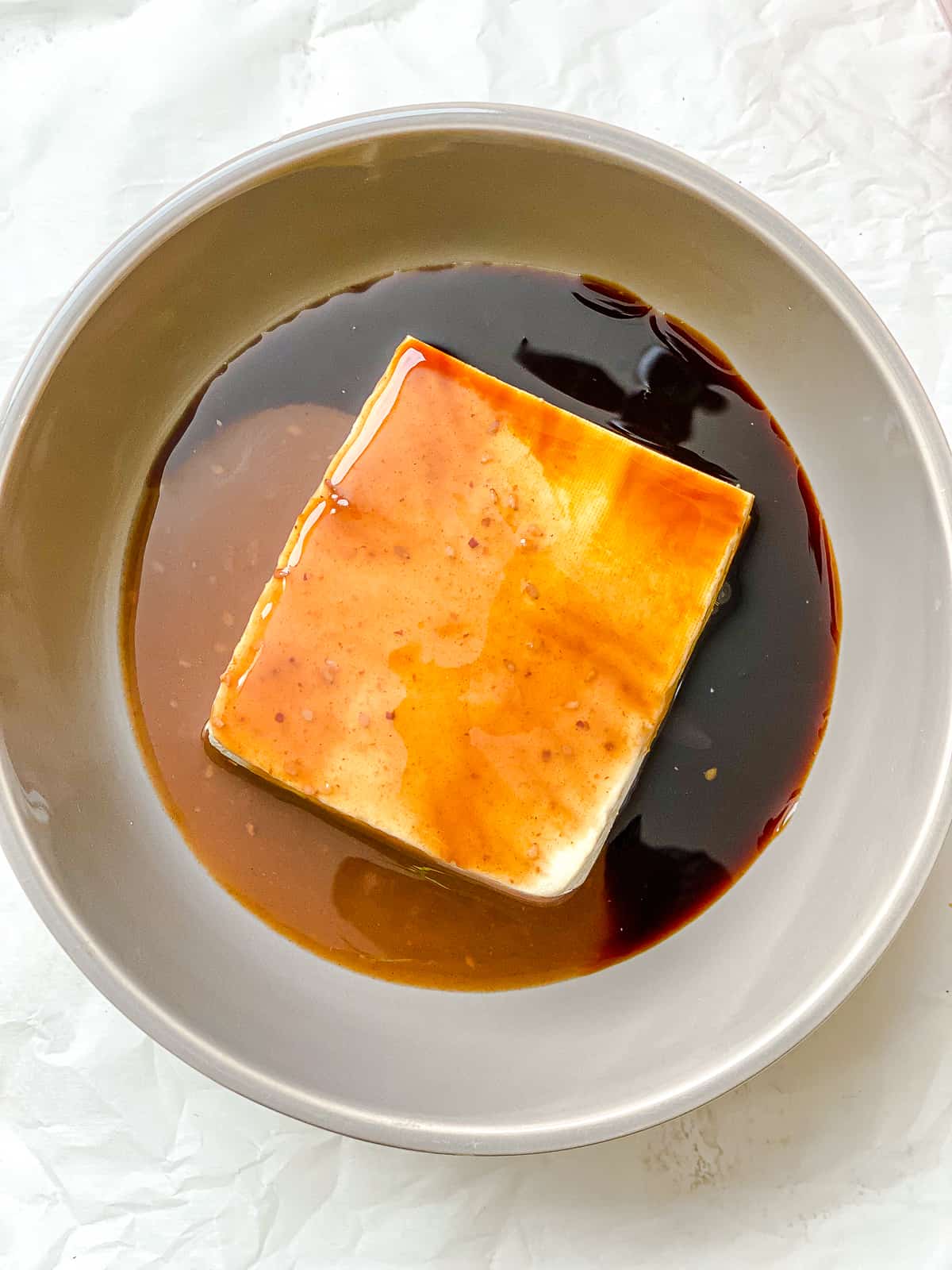 process shot of adding tofu to bowl of sauce