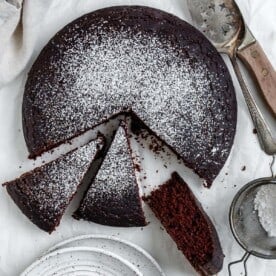 completed EASY Chocolate Depression Cake [Wacky Cake] sliced against a white surface