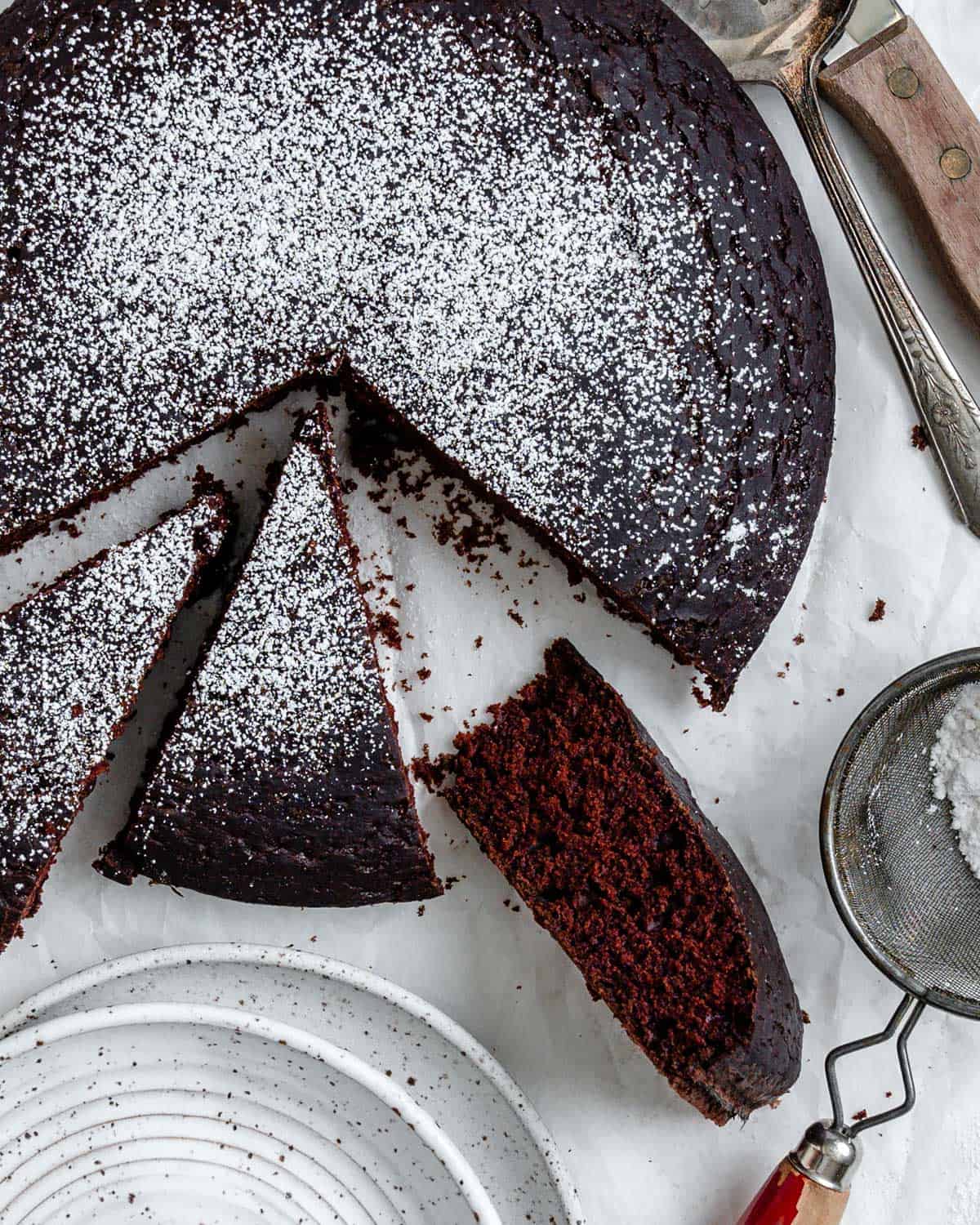 completed EASY Chocolate Depression Cake [Wacky Cake] sliced against a white surface