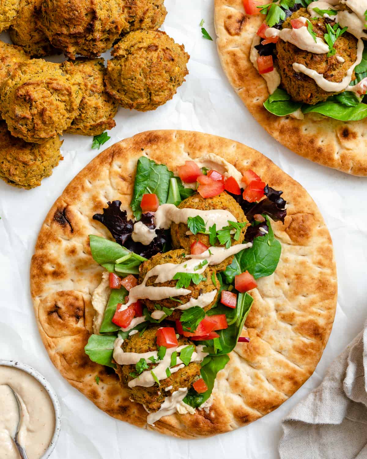 completed Healthy Baked Falafel on bread against a white background