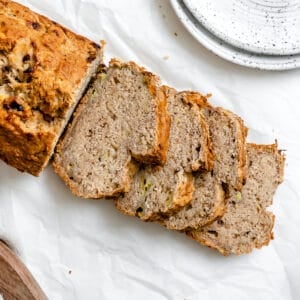 completed sliced Easy Vegan Banana Bread (With Applesauce) in a loaf pan against a white background