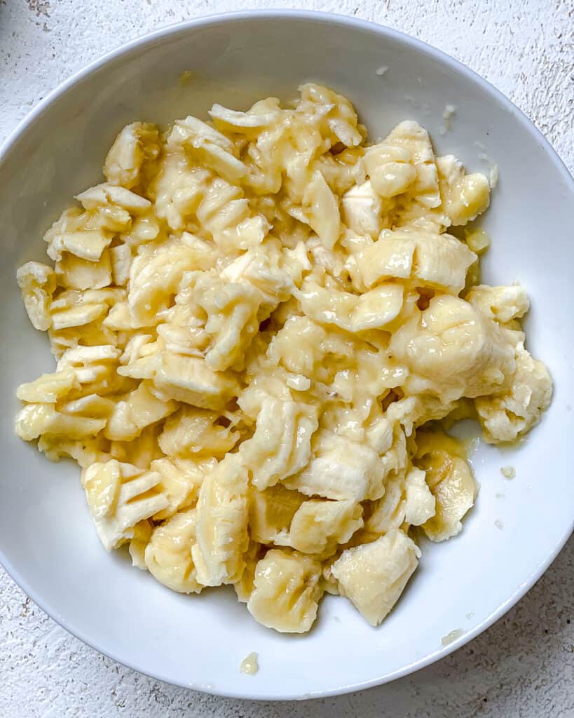 process shot of mashing bananas in a bowl