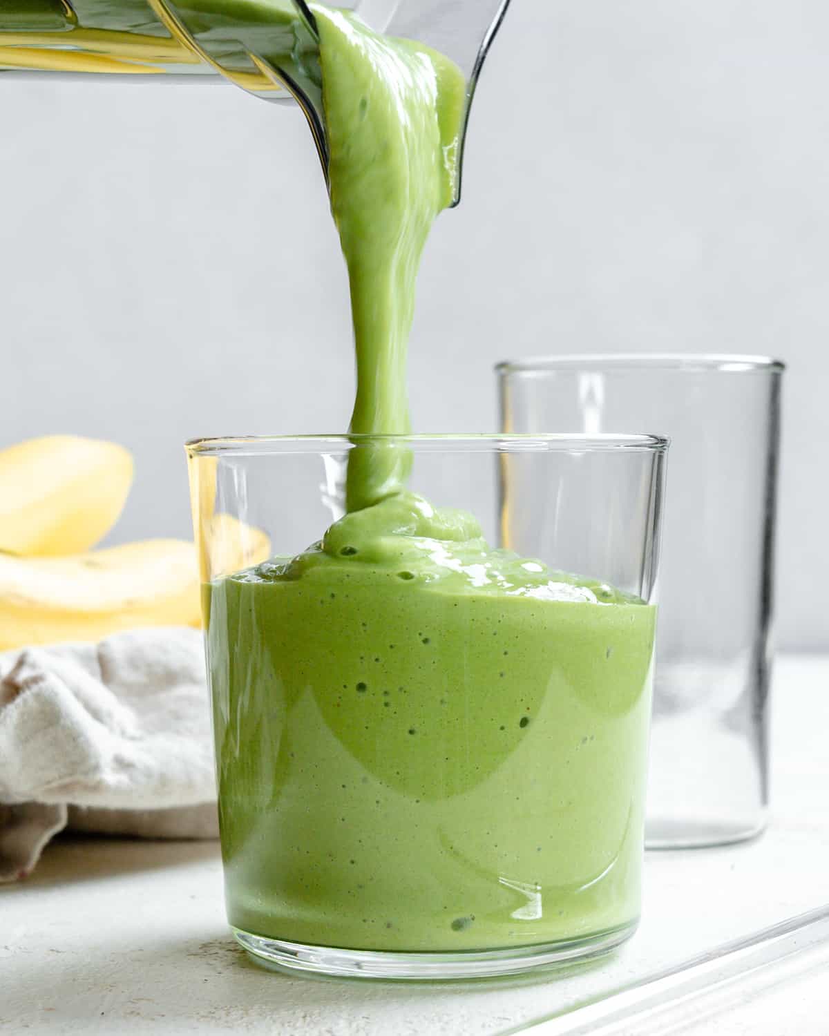 process shot of smoothie being poured into glass container