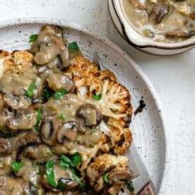 completed Cauliflower Steaks plated on a white plate against a white background