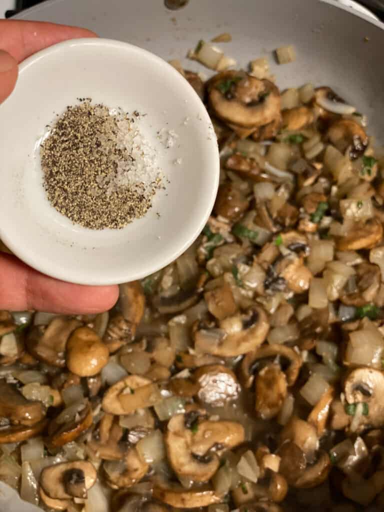 process shot of adding salt and pepper to pan