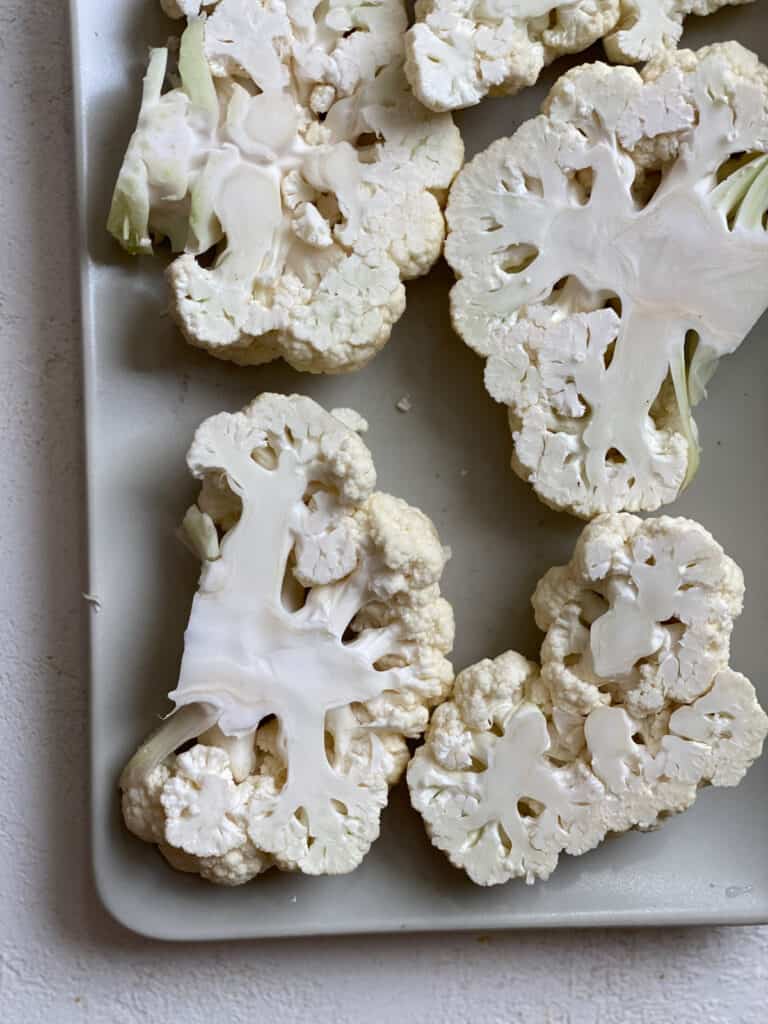 sliced cauliflower on a baking sheet