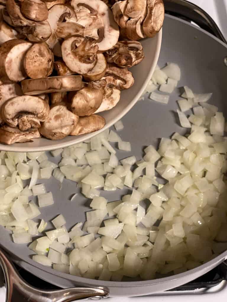 process shot of adding mushrooms to pan