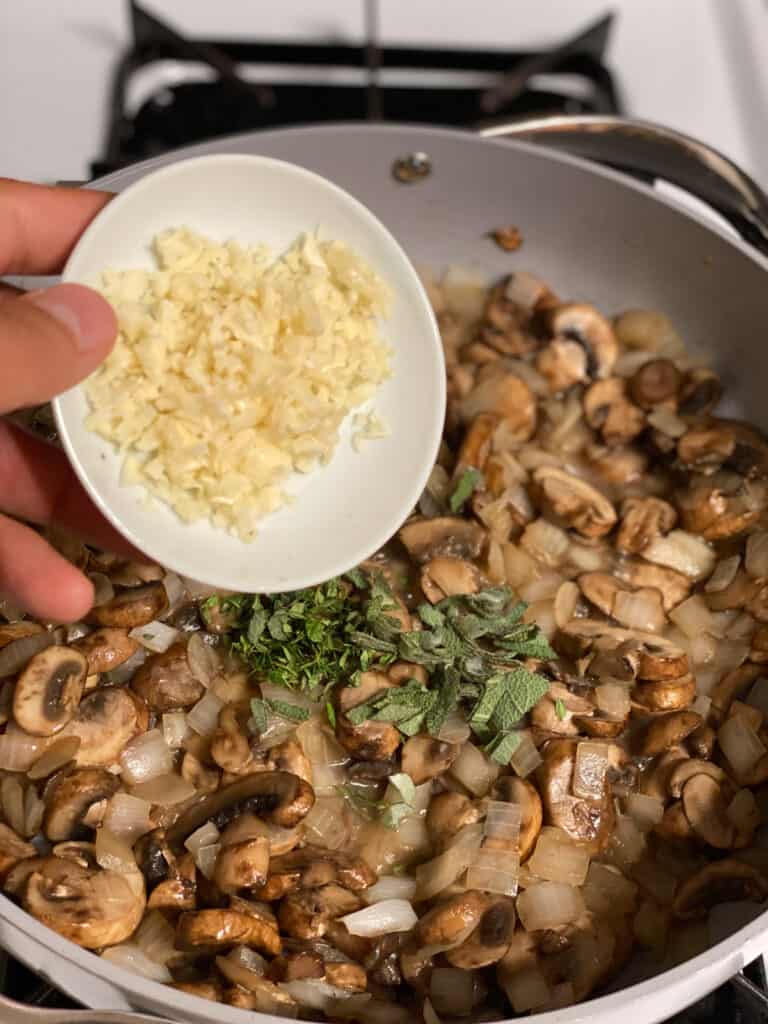 process shot of adding garlic to pan