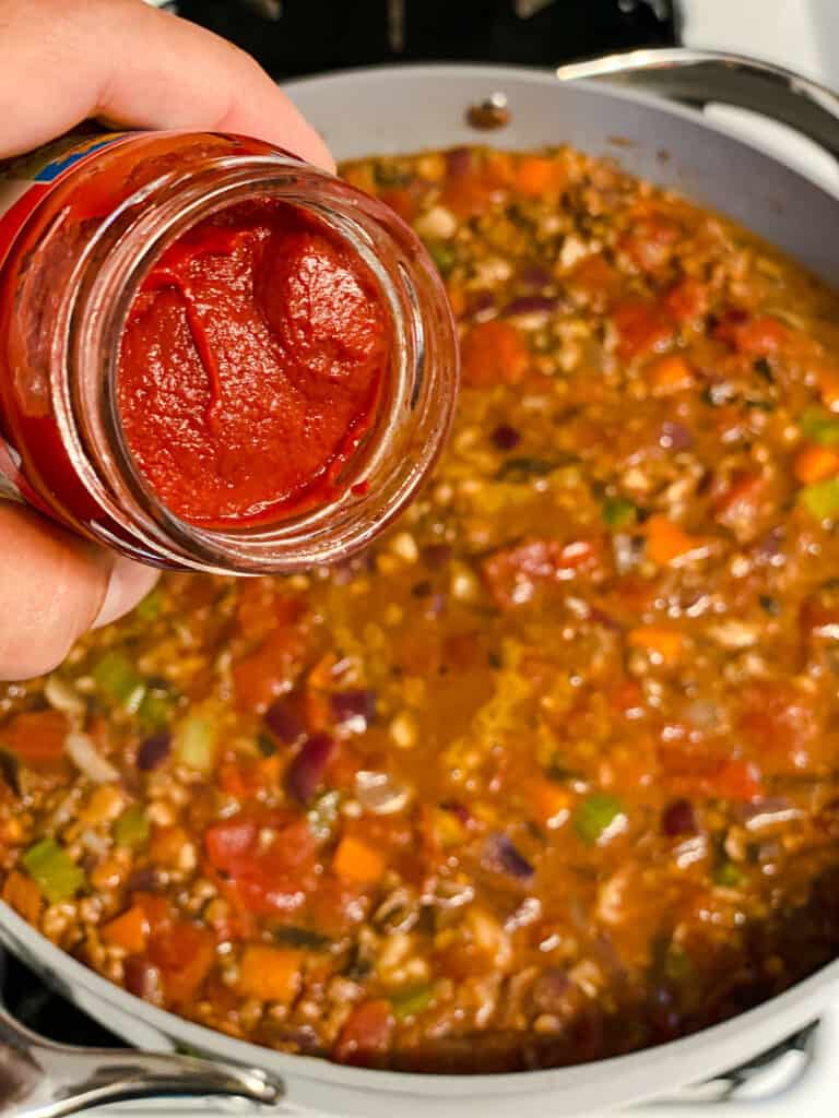 process shot of adding tomato paste to pan