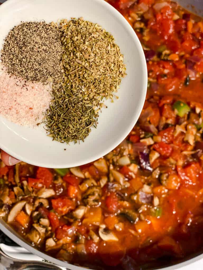 process shot of adding seasonings to pan