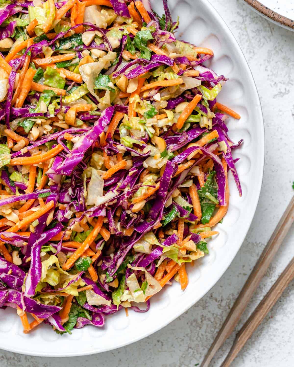 completed Crunchy Thai Peanut Salad in a white bowl against a white background