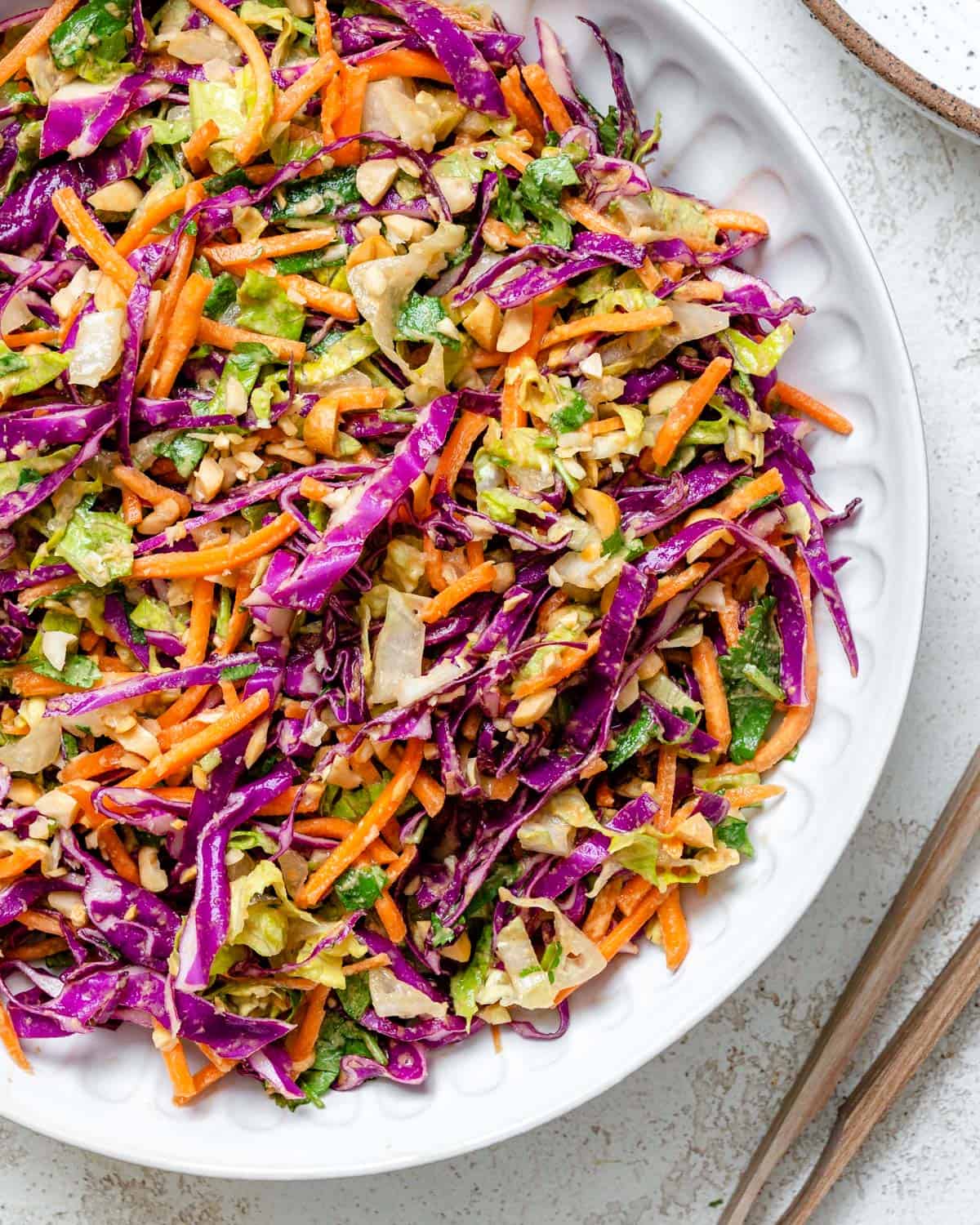 completed Crunchy Thai Peanut Salad in a white bowl against a white background