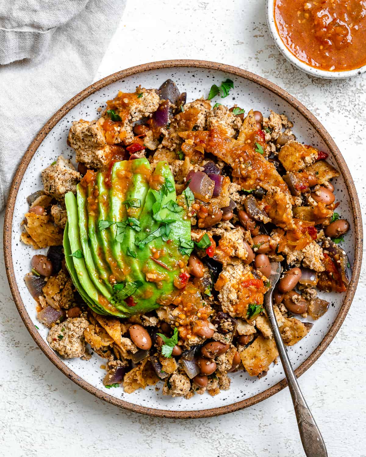 completed Vegan Chilaquiles [Rojos or Verdes] plated on a plate against a white background