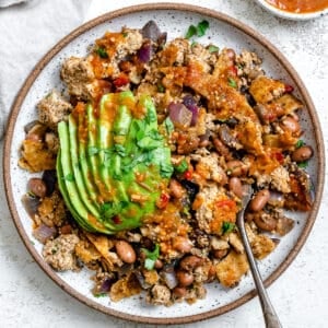 completed Vegan Chilaquiles [Rojos or Verdes] plated on a plate against a white background