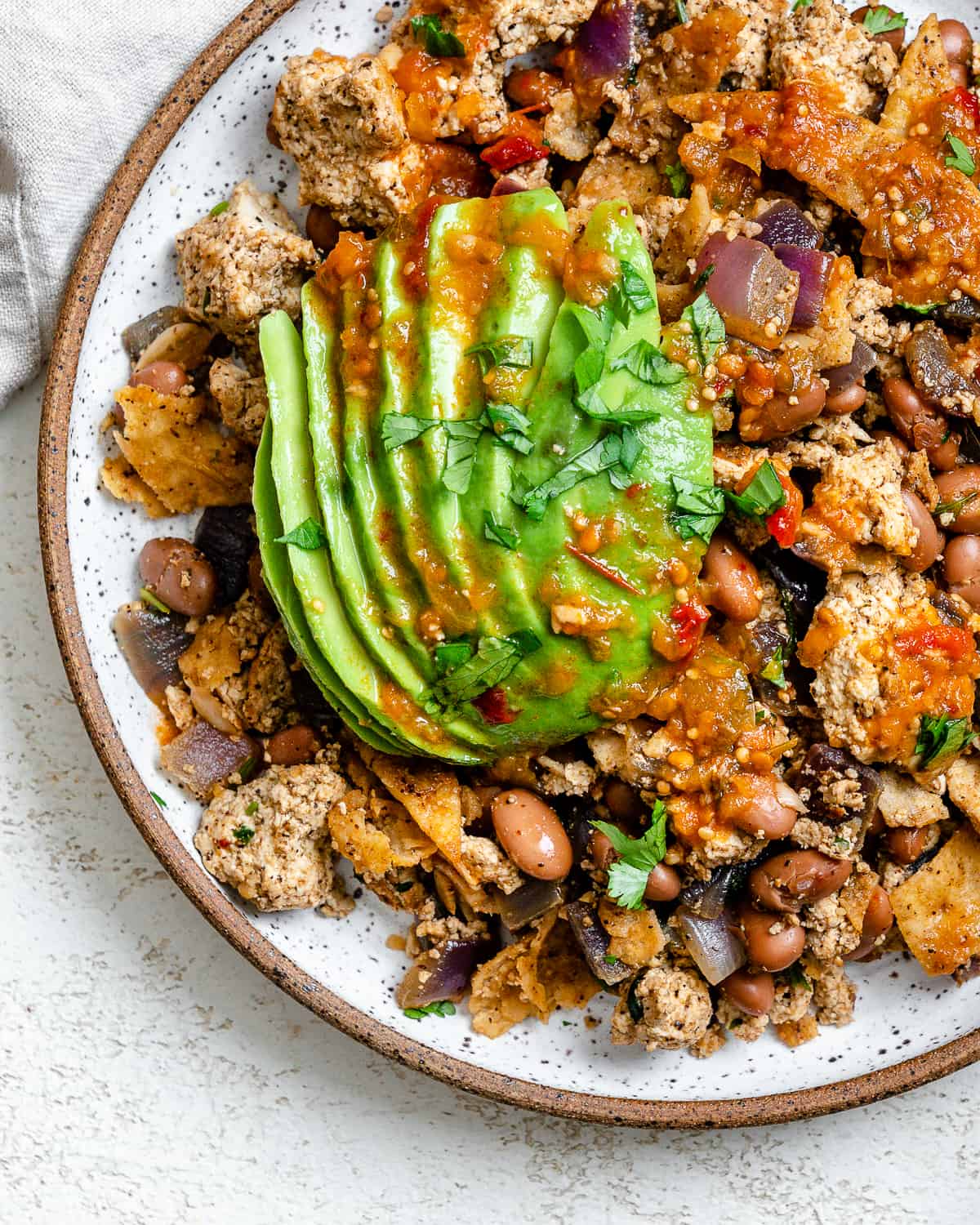 completed Vegan Chilaquiles [Rojos or Verdes] plated on a plate against a white background