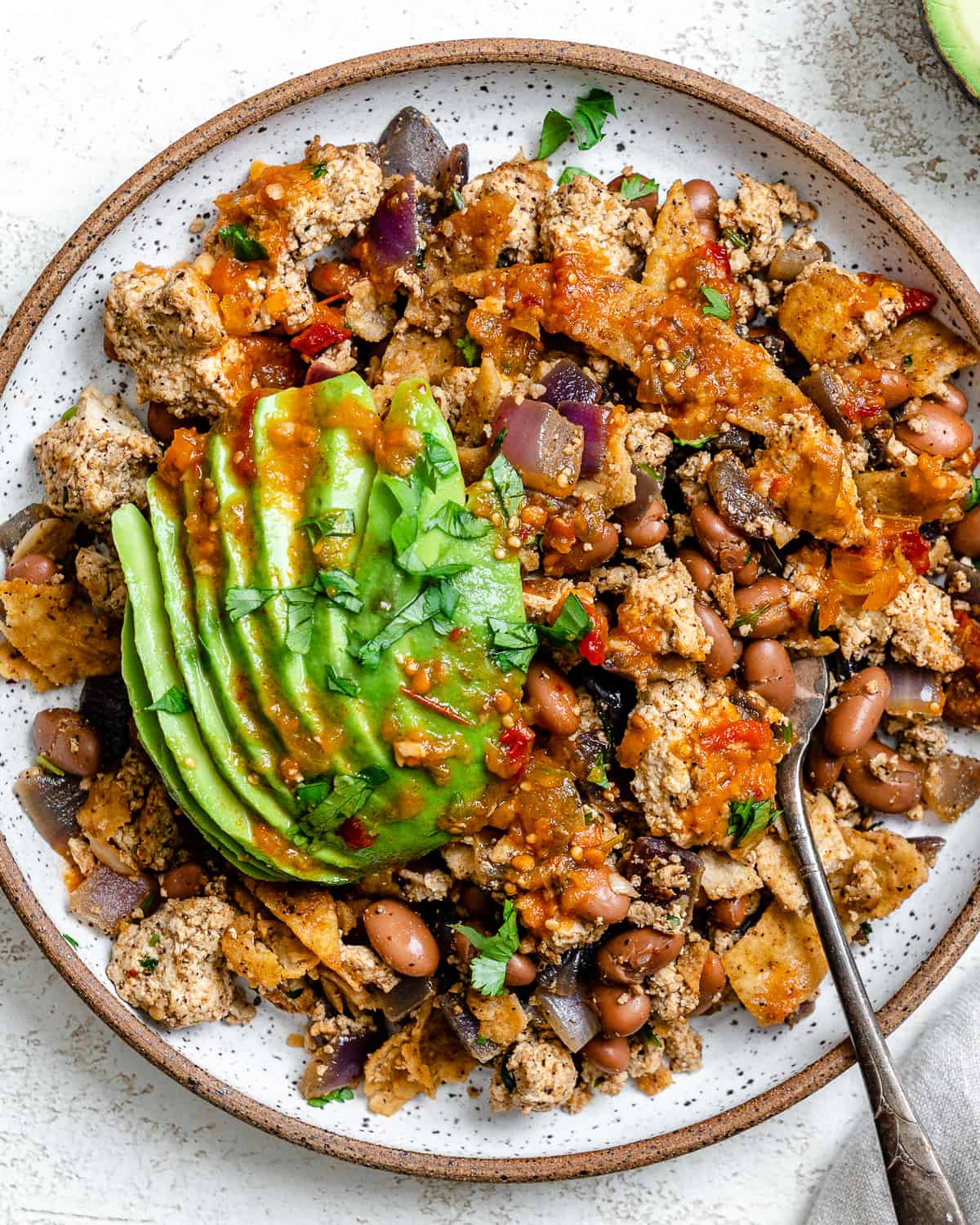 completed Vegan Chilaquiles [Rojos or Verdes] plated on a plate against a white background