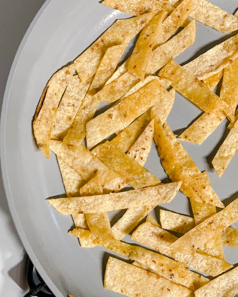 process shot of tortilla strips cooking in pan