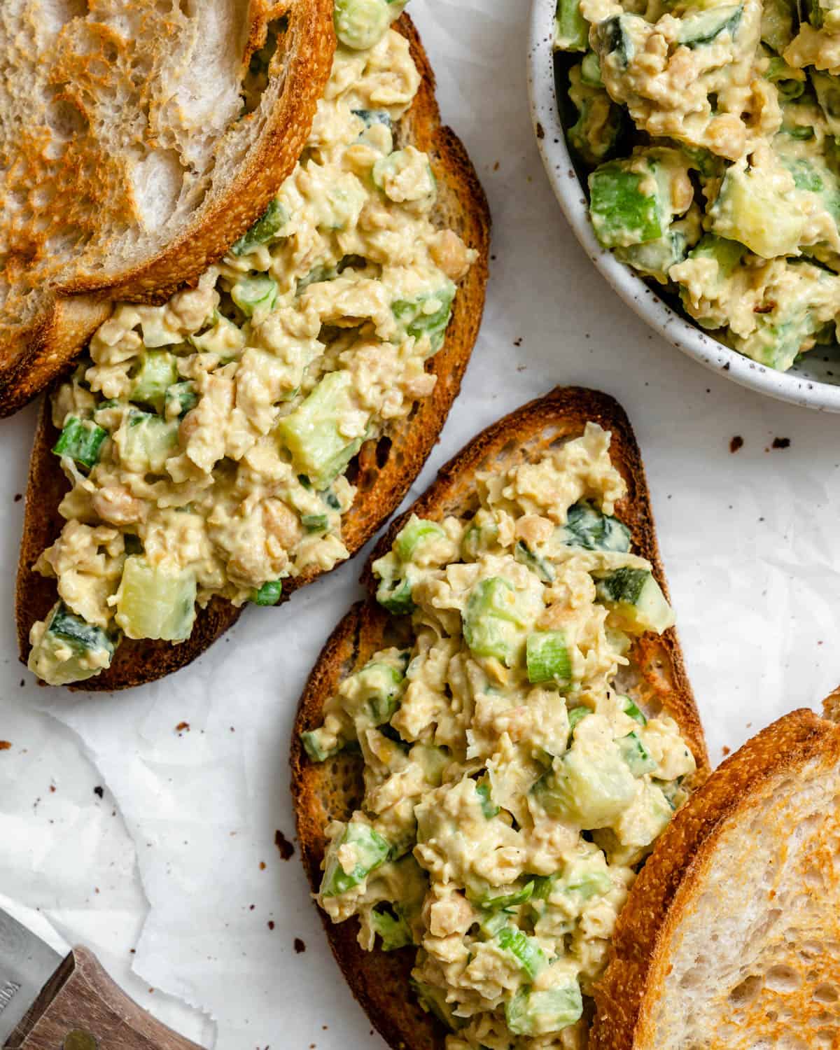 completed Plant-Based Chickpea Tuna Salad on bread against a white surface