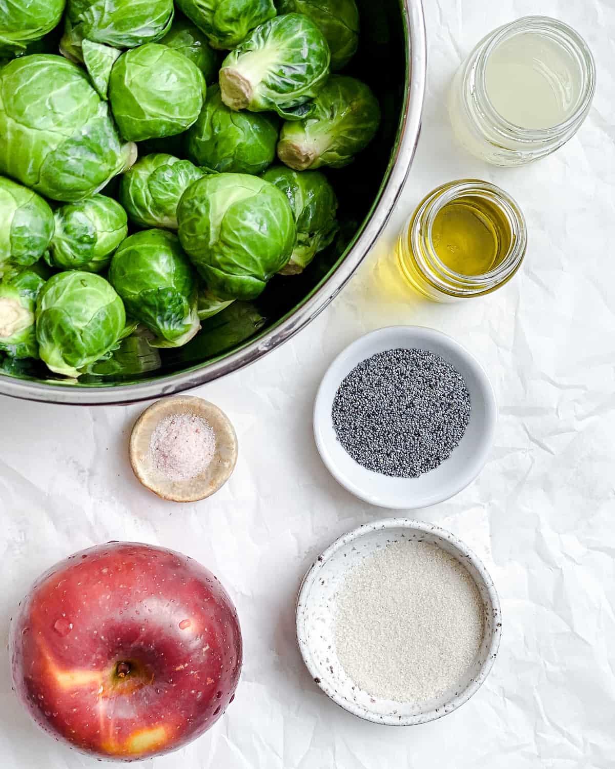 ingredients for Shaved Brussel Sprout Slaw with Apples measured out against a white surface