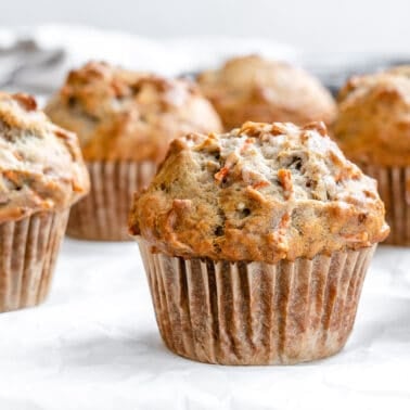 close up of completed Carrot Cake Muffin with several in the background