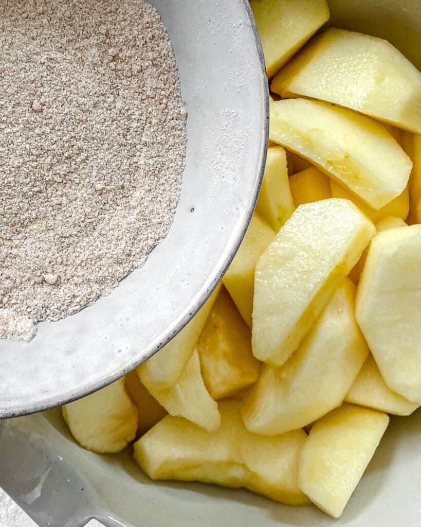 process s hot of flour being added to bowl of apples