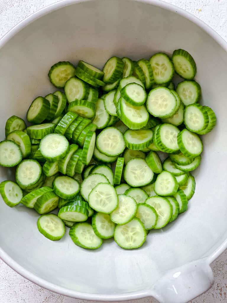 sliced cucumbers in a white bowl