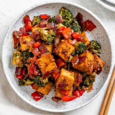 completed Vegan Teriyaki Tofu Stir Fry plated on a white bowl against a light surface