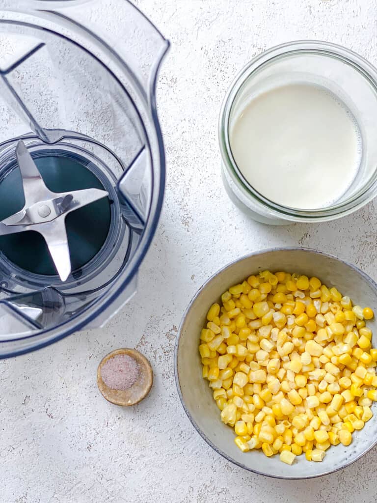 blender alongside corn and cup of milk