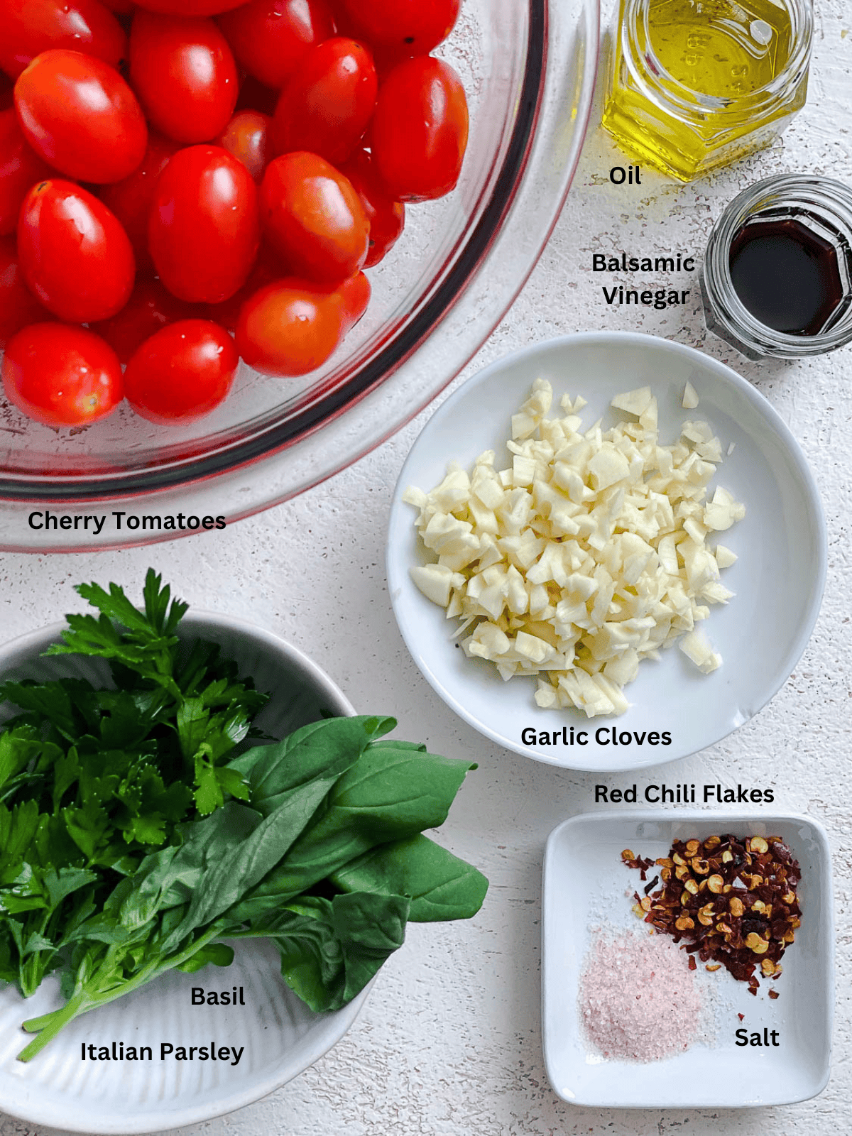 ingredients for Easy Roasted Cherry Tomatoes measured on a white surface