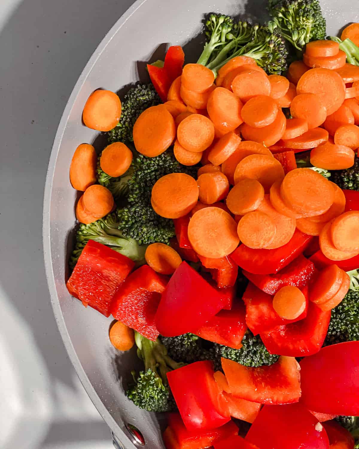 process shot of adding veggies to pan