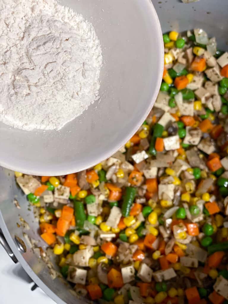 process shot of flour being added to pan