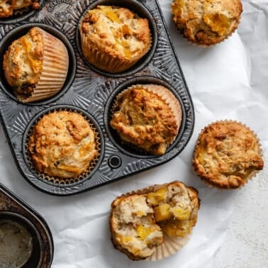 completed Easy Pineapple Muffins [Multiple Ways] in a muffin tray and on a white surface