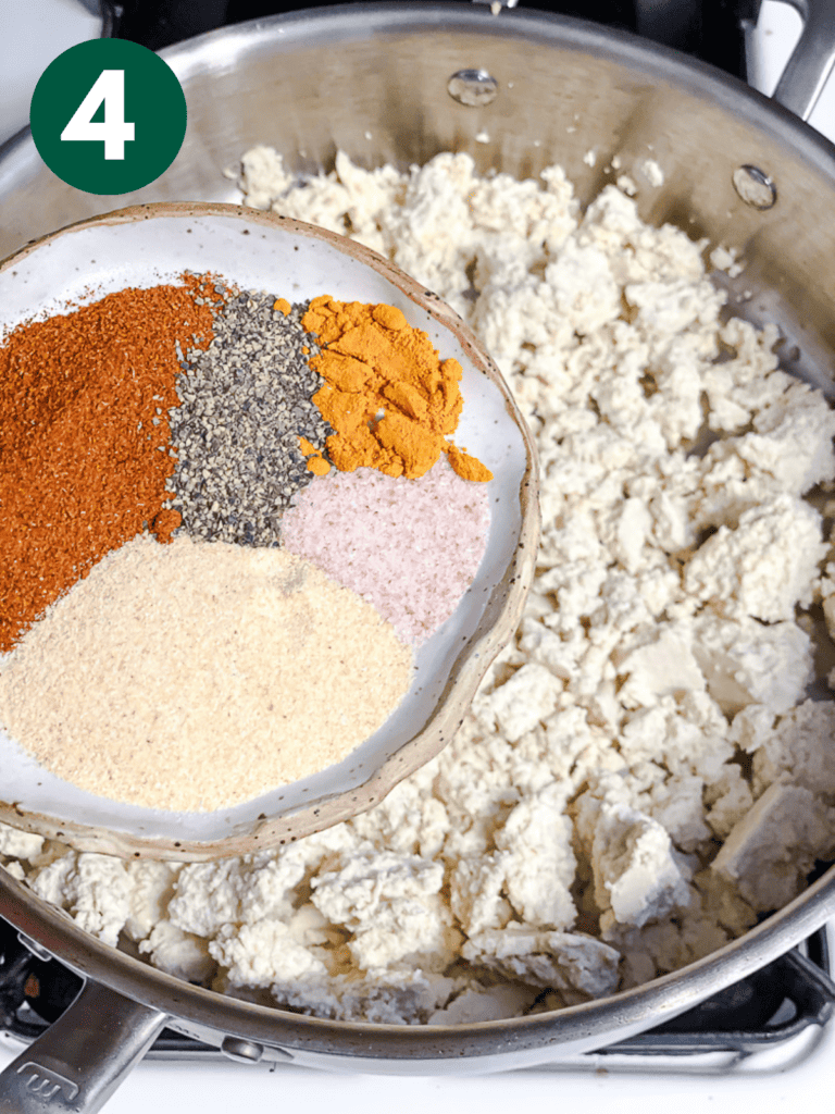 process shot showing the addition of seasonings to pan of tofu