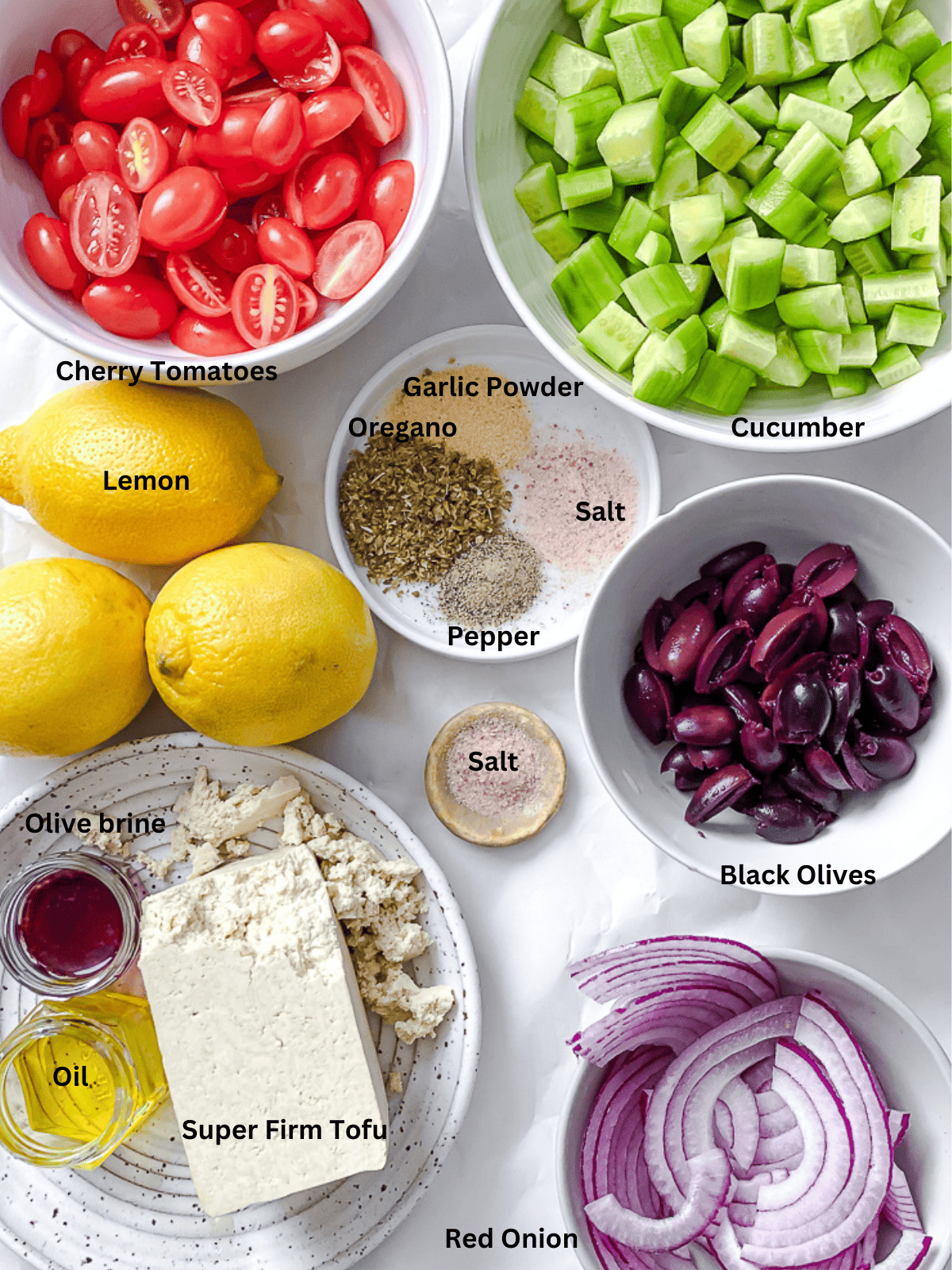 ingredients for Greek Cucumber Salad measured out on a white surface