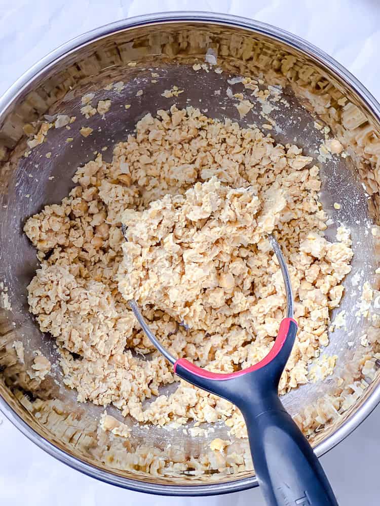 process shot showing mashing chickpeas in bowl