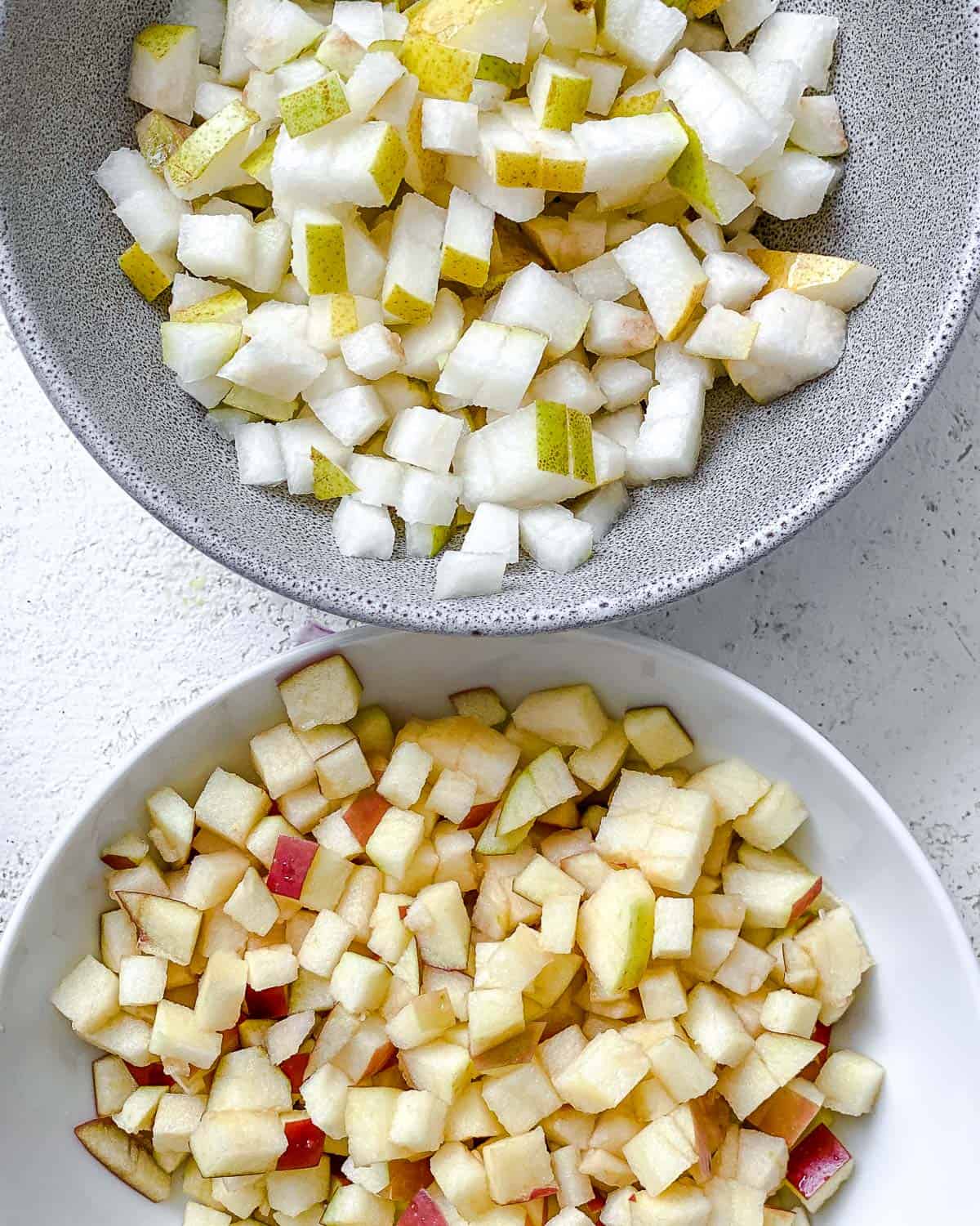 chopped apples and pears in two separate bowls.