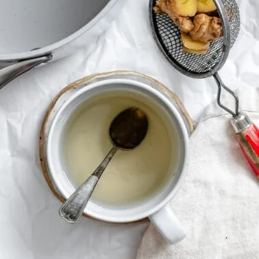 completed ginger tea in a cup against a white background