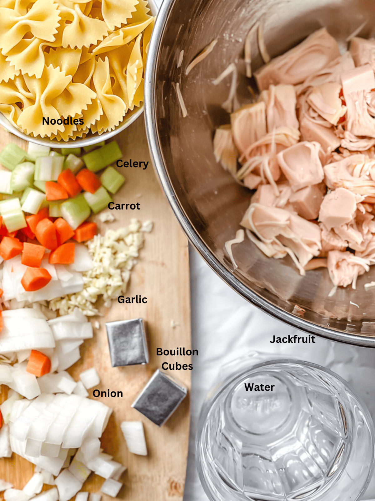 ingredients for Vegan Jackfruit Chicken Noodle Soup on a white surface