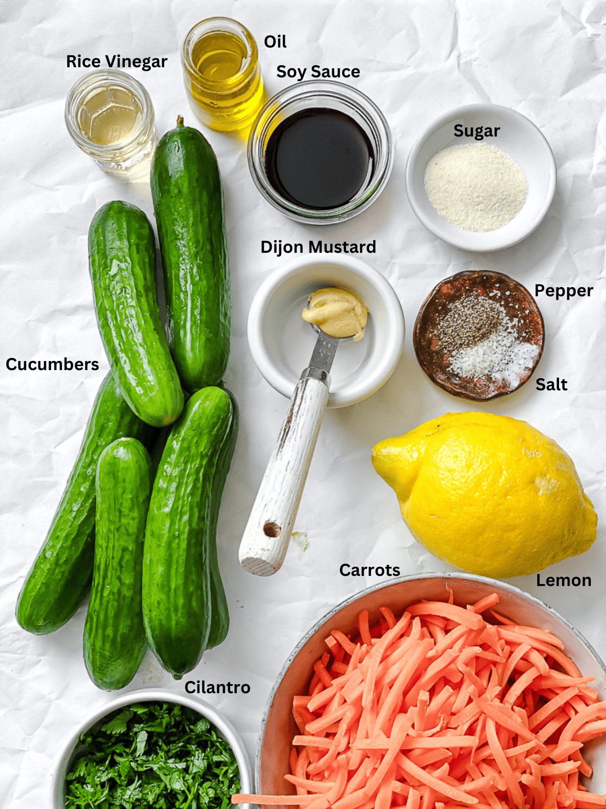 ingredients for Carrot Cucumber Salad measured out on a white surface