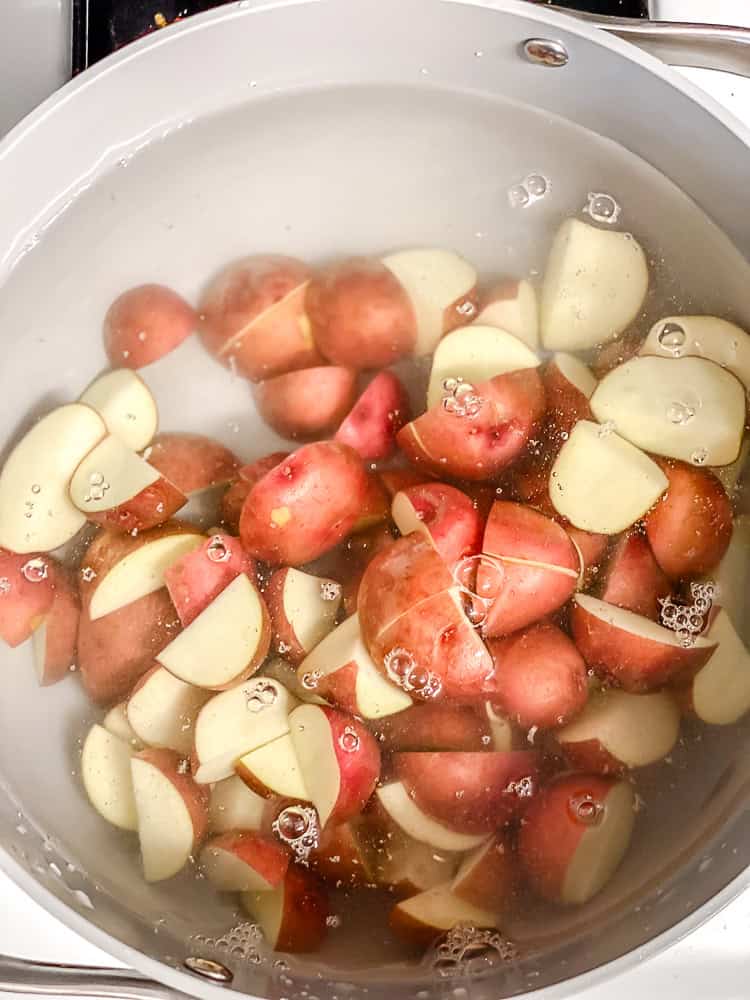 chopped red baby potatoes in a pot of water.