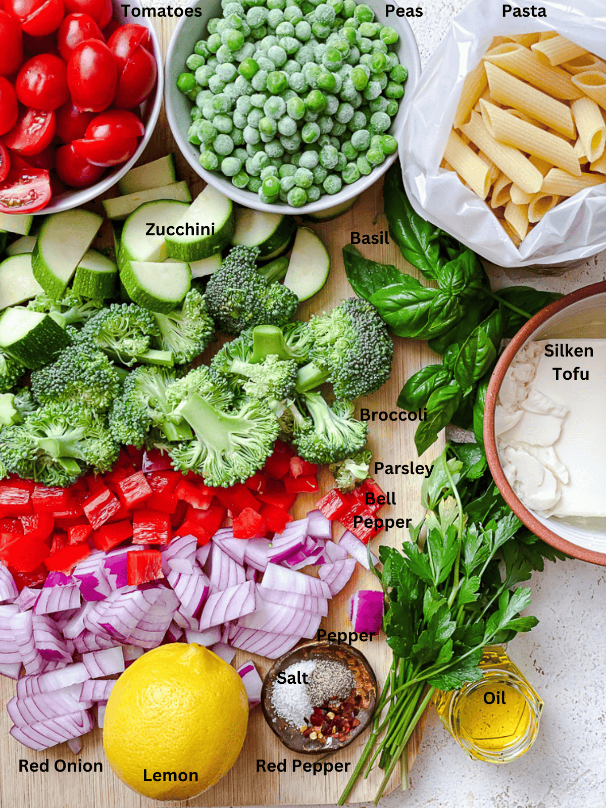 ingredients for Vegan Pasta Primavera in individual bowls with labels.