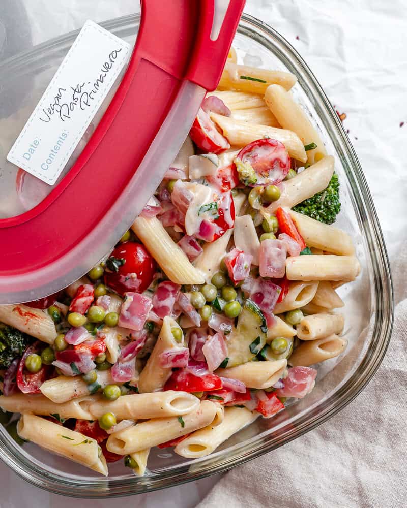 leftover vegan pasta primavera in a glass storage container.