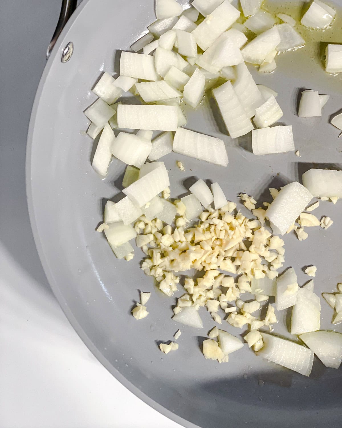 process shot showing onions and garlic cooking in pan