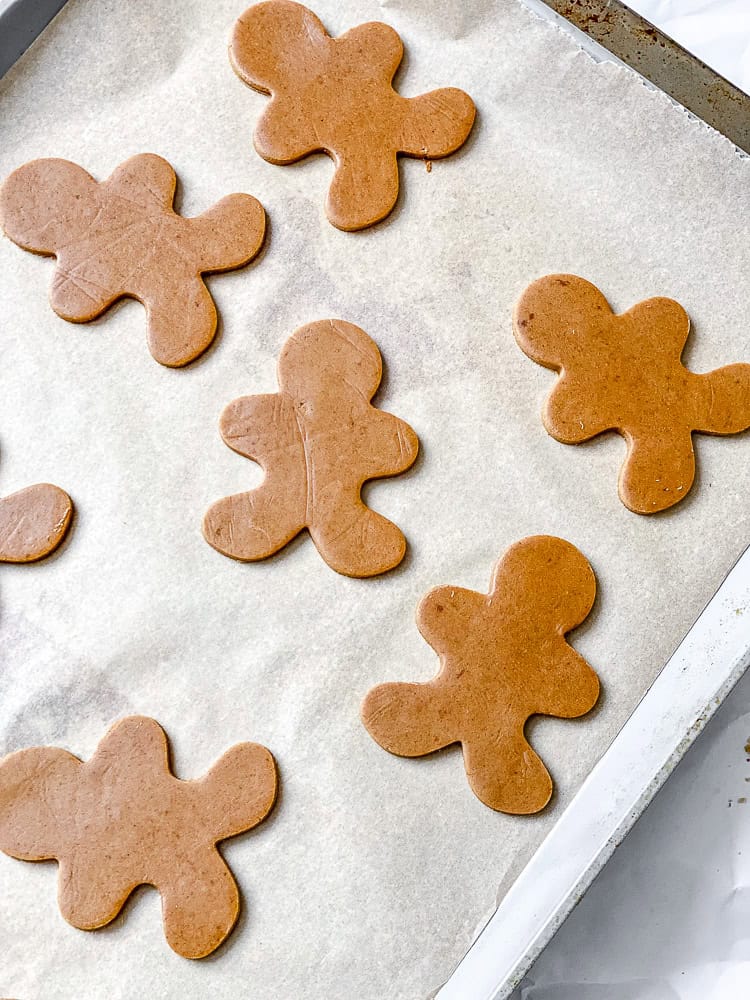 process shot showing gingerbread men cut outs on baking sheet